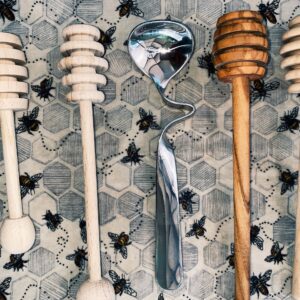 Honey dippers on bee-patterned cloth