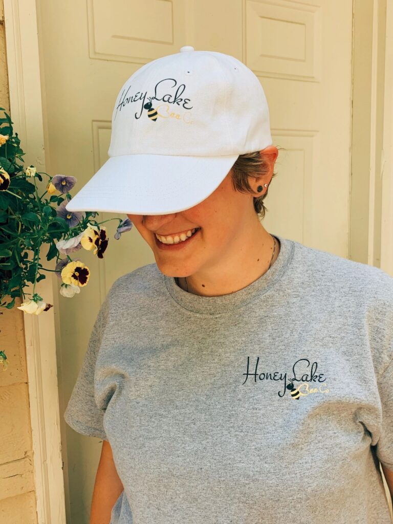 Smiling individual in branded cap and tee