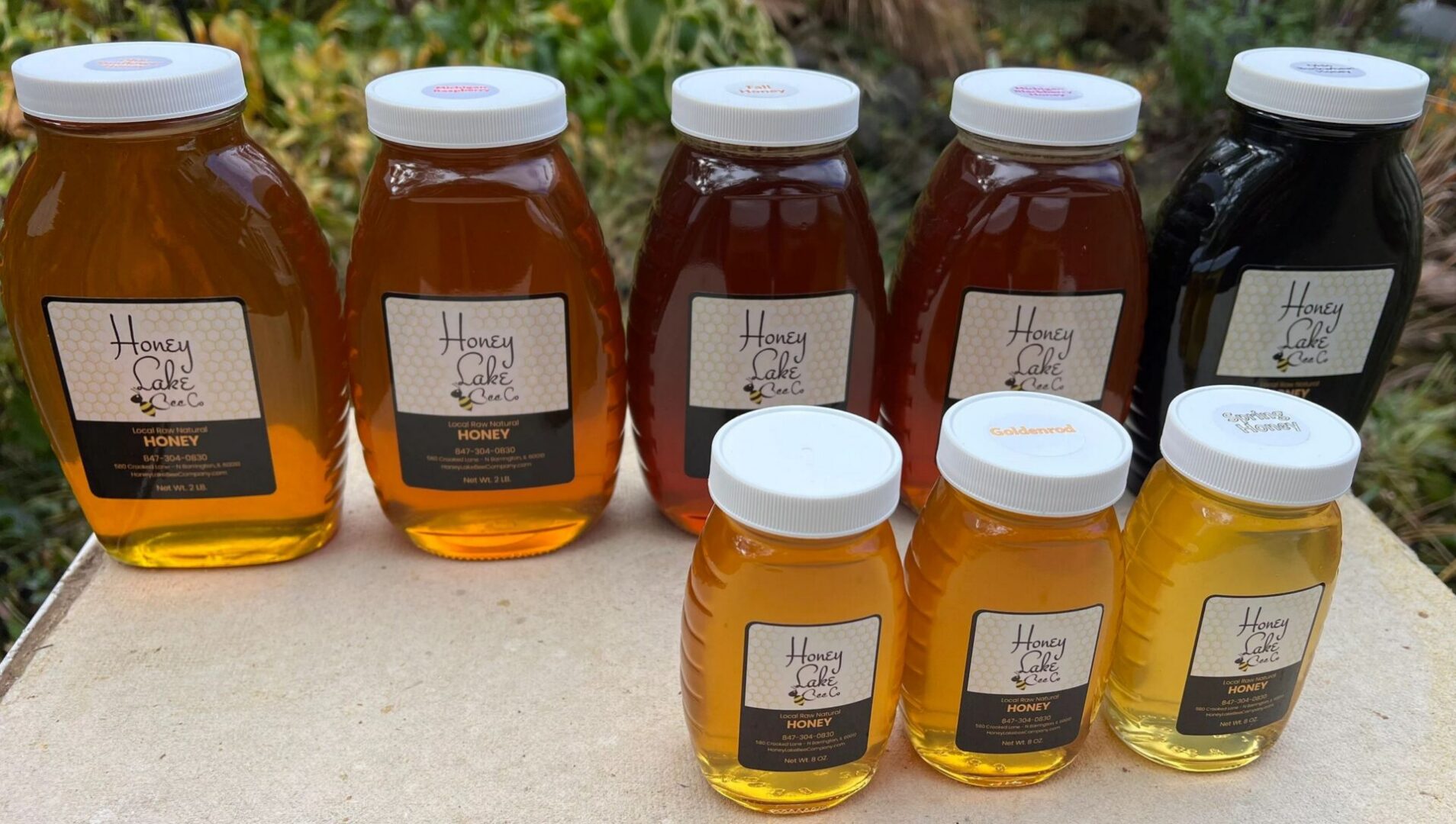 Variety of honey bottles outdoors