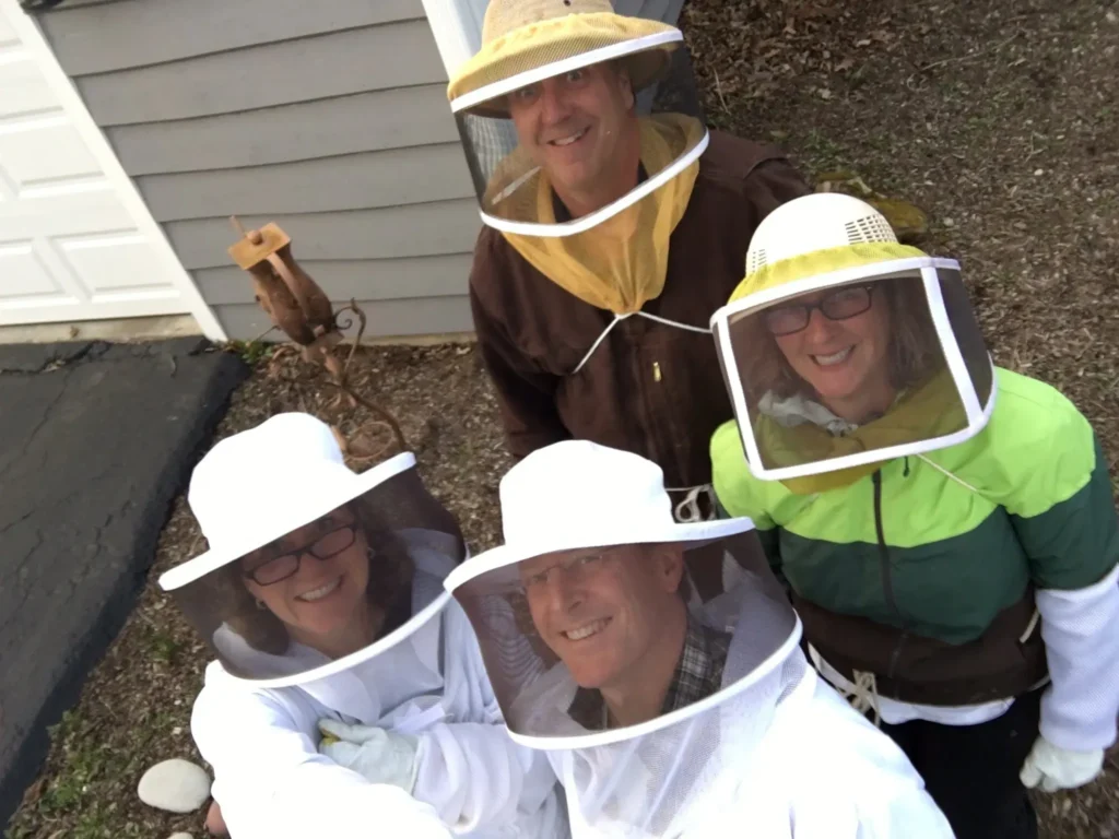Beekeepers smiling in protective gear