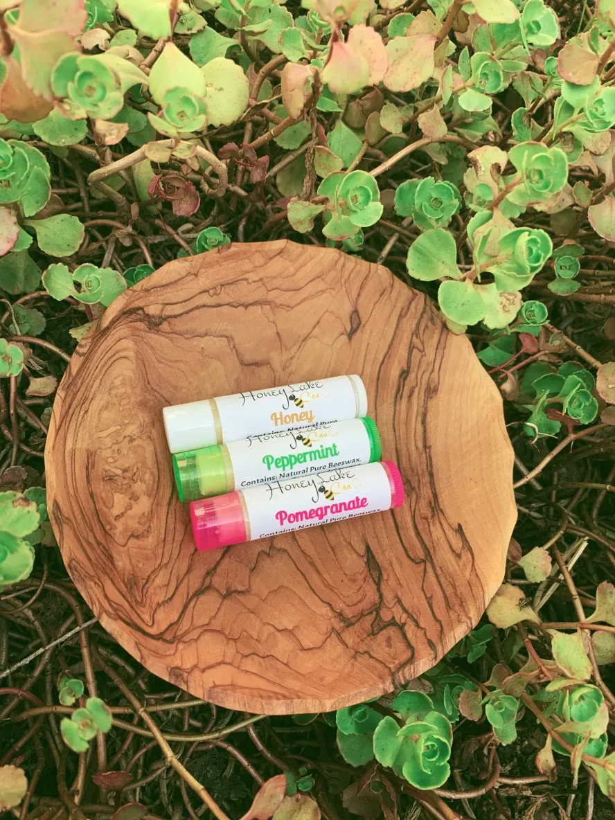 Lip balms on wooden plate with plants