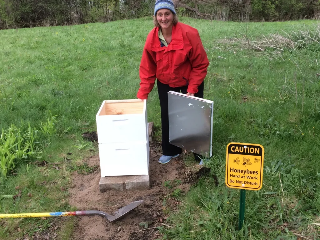 Woman smiling beside beehive setup