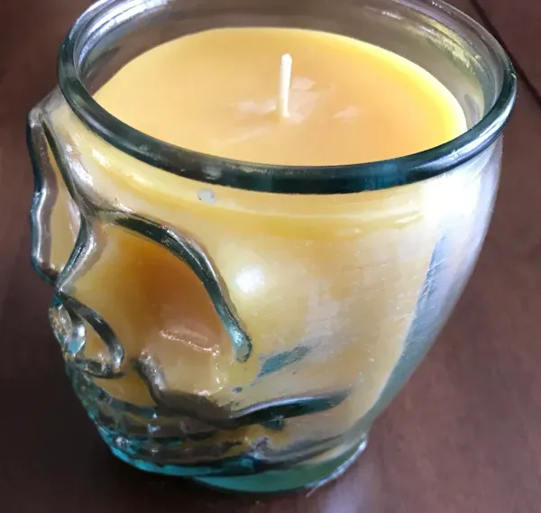 Yellow candle in skull-shaped glass