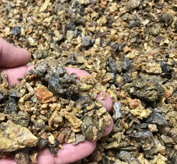 Person holding crushed ore fragments