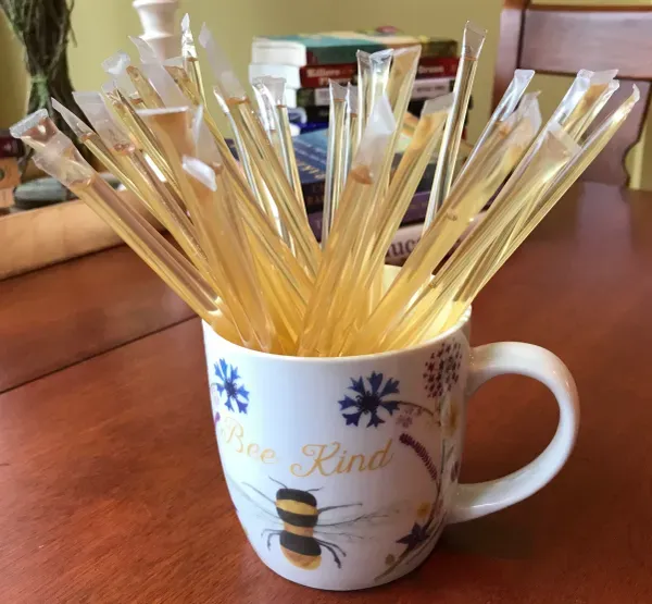 Honey sticks in decorative mug